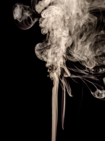White smoke isolated on a black background, raised in curls as an abstract effectの写真素材
