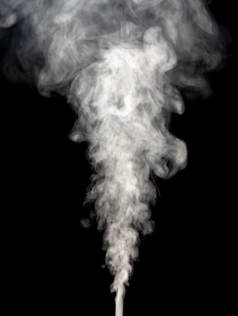 Fluffy white smoke rises isolated on a black backgroundの写真素材