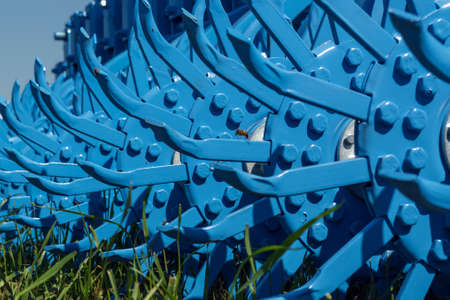 teeth and knots of a rotary harrow standing on the grass.の写真素材