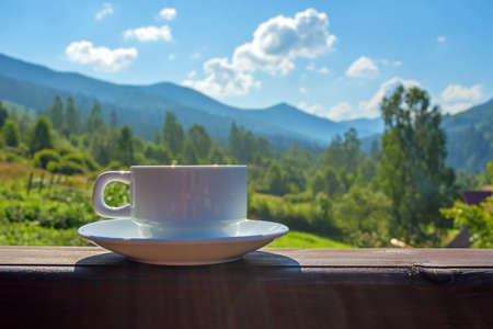 a cup of tea, coffee, standing on the porch of the hotel balcony, overlooking the mountains, in the early morning in the sunlight.の写真素材