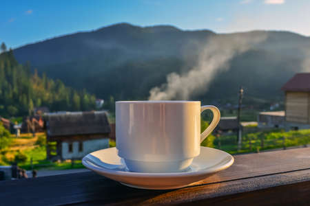 a cup of tea, coffee, standing on the porch of the hotel balcony, overlooking the mountains, in the early morning in the sunlight.の写真素材