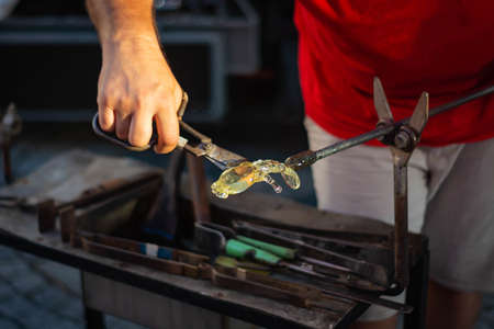 making figurines from glass, just pulled out of the oven, by a master with the help of an instrementの写真素材