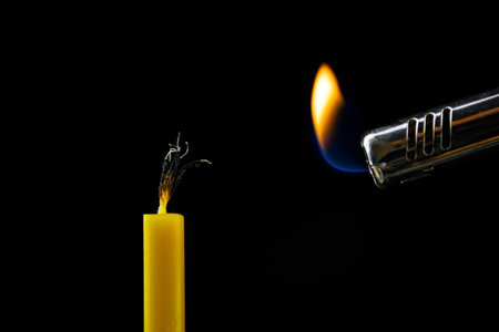 church wax candle burns on a black background.