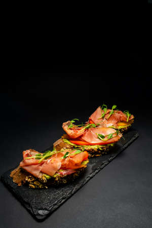 fresh bruschetta with shrimp, cheese, ham and microgreens.の写真素材