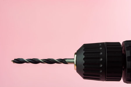 electric drill with a drill on a pink background.の写真素材
