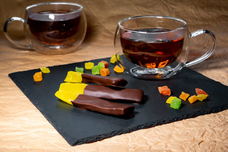 pieces of passion fruit in chocolate on the background of a cup of tea.の写真素材