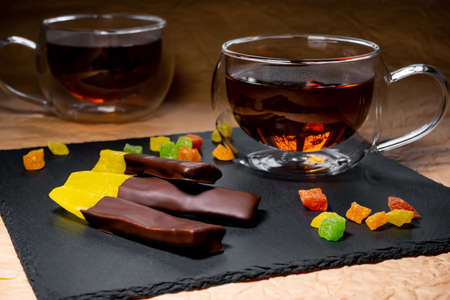 pieces of passion fruit in chocolate on the background of a cup of tea.の写真素材