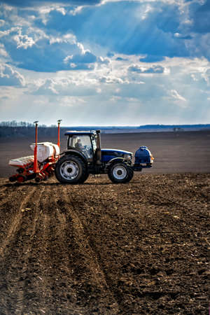 sowing work in the field. Tractor with seeder.の写真素材