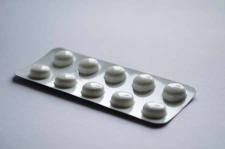 Ten pills in blister pack close-up on gray background.の写真素材