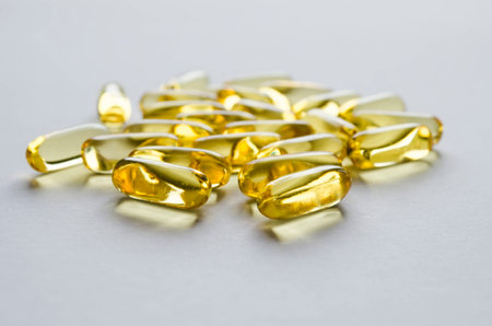 Close-up yellow transparent capsules on a gray background.の写真素材