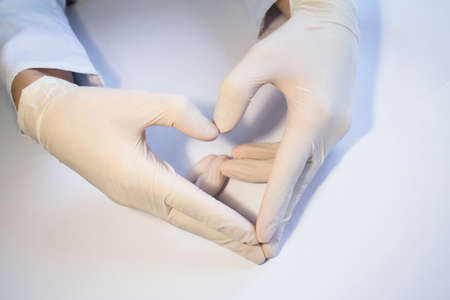 Hands in medical rubber gloves show the shape of the heart.の写真素材