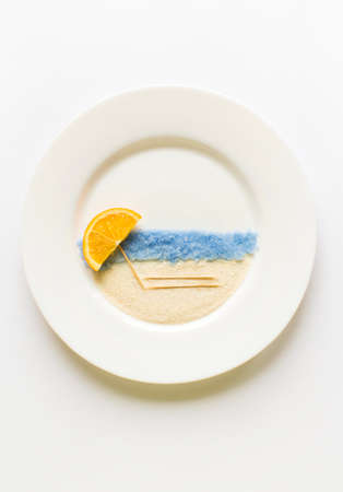 The concept of the beach and sea of oranges on a white round plate vertical.の写真素材