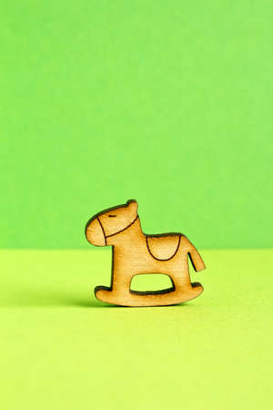 Wooden icon of children's rocking horse on green background verticalの写真素材