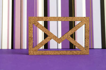 Wooden envelope icon on purple striped background.の写真素材