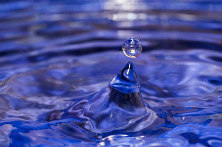 Water splash with one drop on blue background.