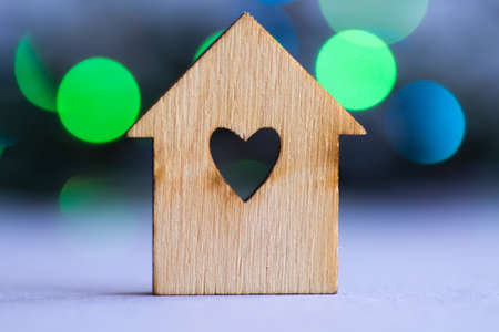 Wooden house with hole in the form of heart on blue and green bokeh backgroundの写真素材
