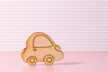 Wooden car icon on pink striped background.の写真素材