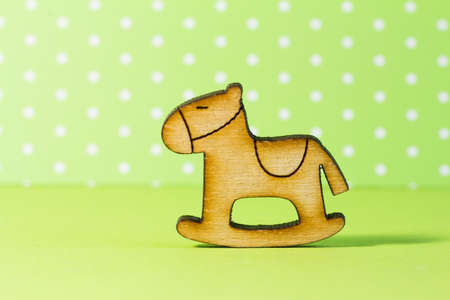 Wooden icon of children's rocking horse on green background.の写真素材