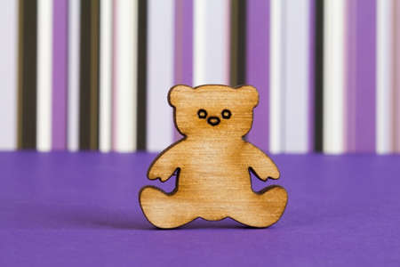 Wooden icon of Teddy bear on purple striped background.の写真素材
