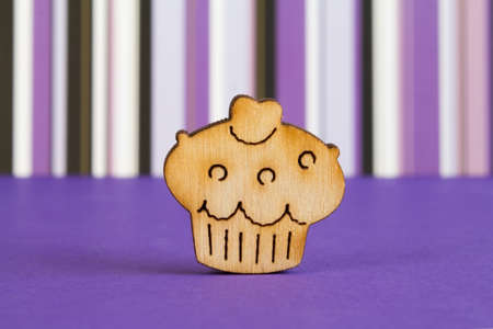 Wooden icon of cake on purple striped background.の写真素材