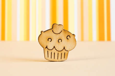 Wooden icon of cake on orange striped background.の写真素材