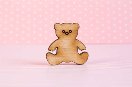 Wooden icon of Teddy bear on pink background.の写真素材