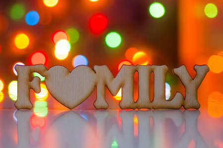 Wooden inscription Family with garland lights on background.の写真素材