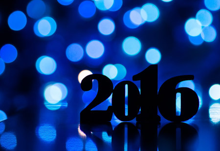 Silhouette of inscription of 2016 year with blue garland lights on dark background.