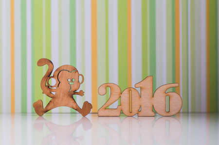Wooden sign of monkey and incsription of 2016 year on green striped background. Concept of Eastern horoscope.の写真素材