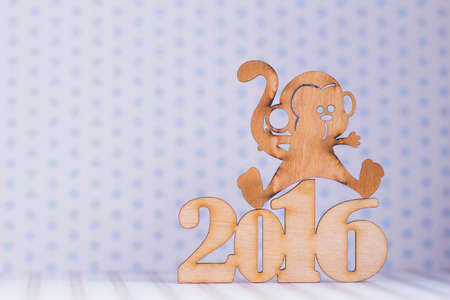 Wooden sign of monkey and inscription of 2016 year on light background. Concept of Eastern horoscope.の写真素材