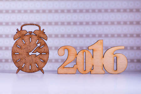 Wooden sign of alarm clock and inscription of 2016 year on lilac background.の写真素材