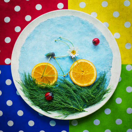 Vintage concept of healthy lifestyle: sport and diet. Healthy food illustrating bicycle on white round plate.の写真素材
