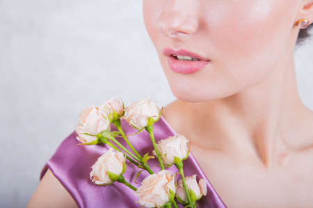Part of beautiful young girl`s face with creamy roses bouquet.の写真素材