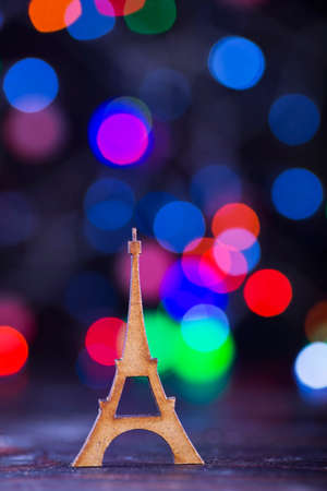 Wooden Eiffel Tower with garland lights on colorful bokeh background.の写真素材