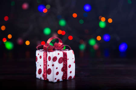Gift box with garland lights on colorful bokeh background.の写真素材