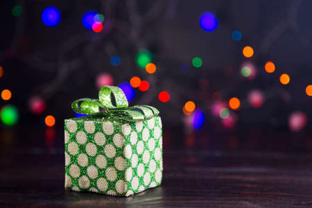 Gift box with garland lights on colorful bokeh background.の写真素材
