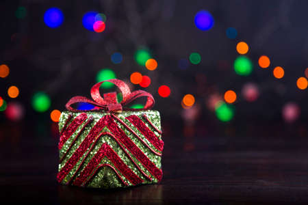 Gift box with garland lights on colorful bokeh background.の写真素材