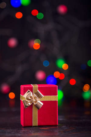 Gift box with garland lights on colorful bokeh background.の写真素材