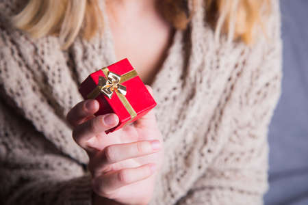 Young female hand holding single gift box.の写真素材