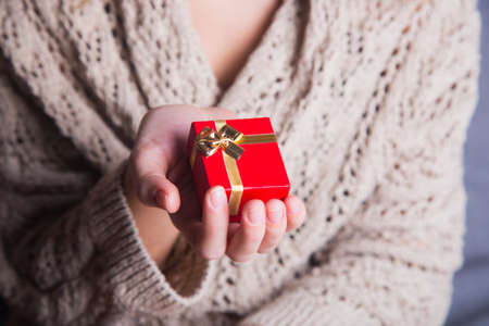 Young female hand holding single gift box.の写真素材