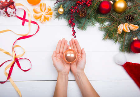 Hands holding warm ball on Christmas decorations background.の写真素材