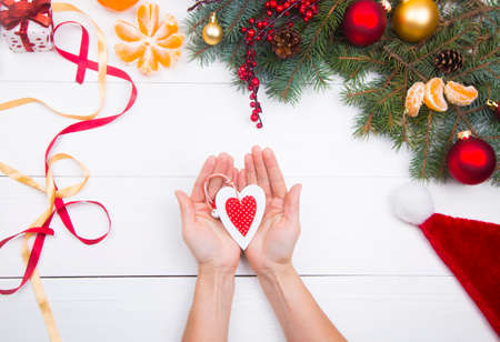 Hands holding vintage heart on Christmas decorations background.の写真素材