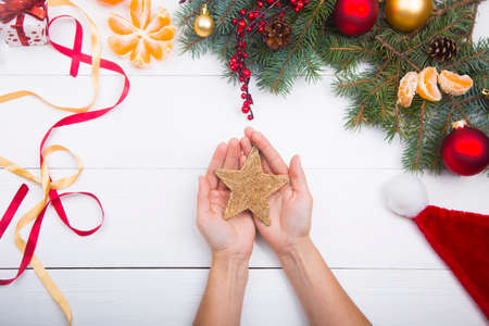 Hands holding golden star on Christmas decorations background.の写真素材