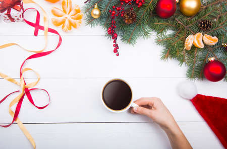 Hand holding coffee cup on Christmas decorations background.の写真素材