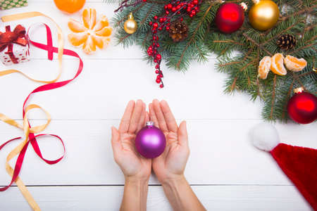Hands holding purple ball on Christmas decorations background.の写真素材