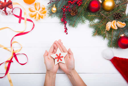 Hands holding star with snowflake on Christmas decorations background.の写真素材