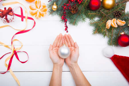 Hands holding white ball on Christmas decorations background.の写真素材
