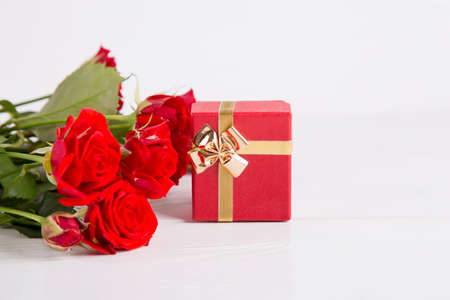 Bouquet of red roses with red gift box on white background.の写真素材
