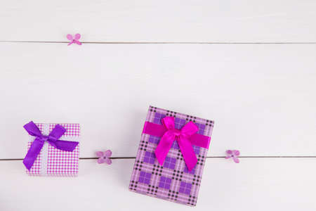Two purple gift boxes surrounded by lilac flowers on white background.の写真素材