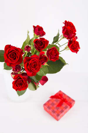 Bouquet of red roses with red gift box on white background.の写真素材